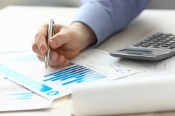 Person zeigt mit Stift auf Akten