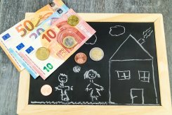 Tafel mit Kinderzeichnung darauf und Bargeld